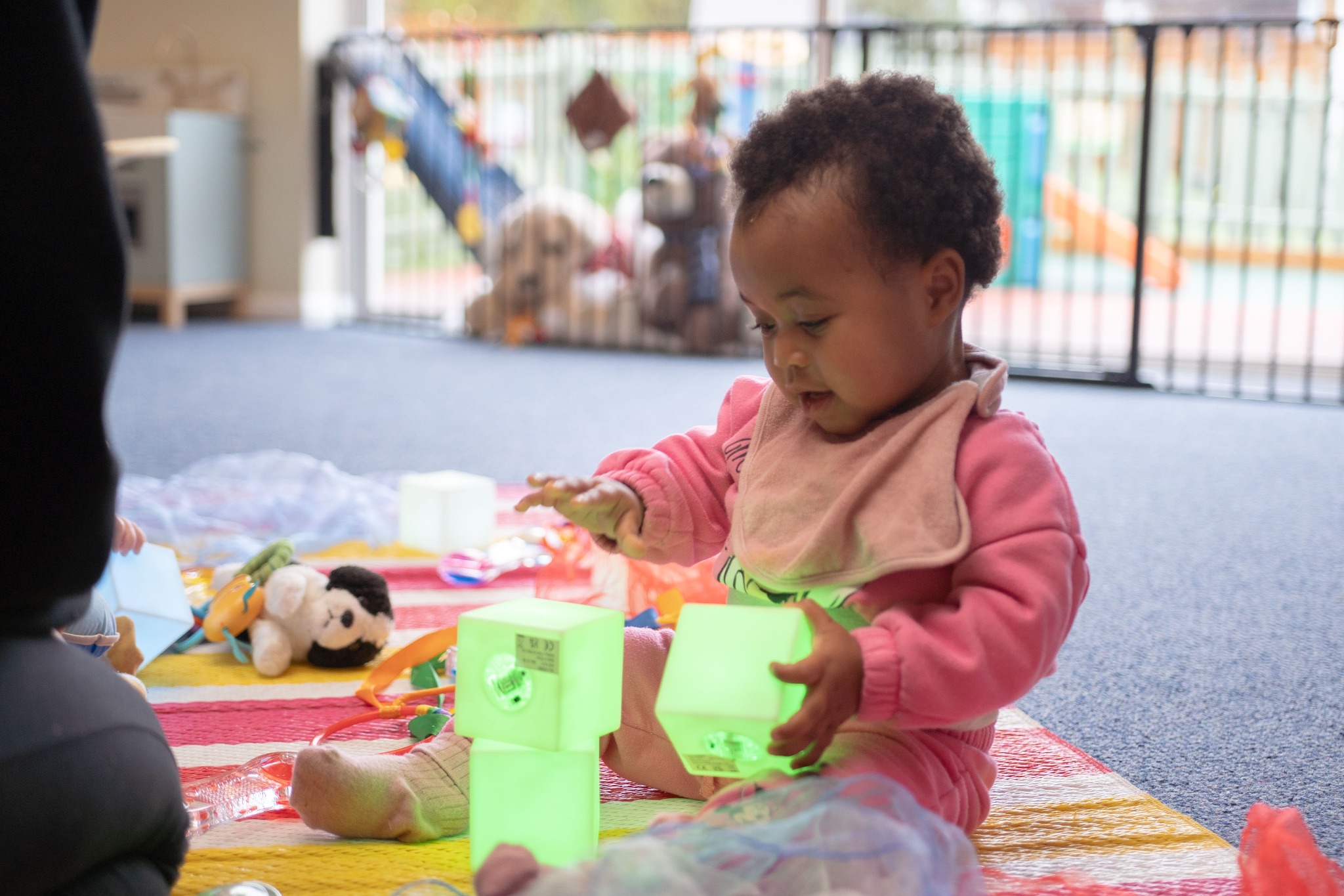A baby absorbed in play with colourful blocks